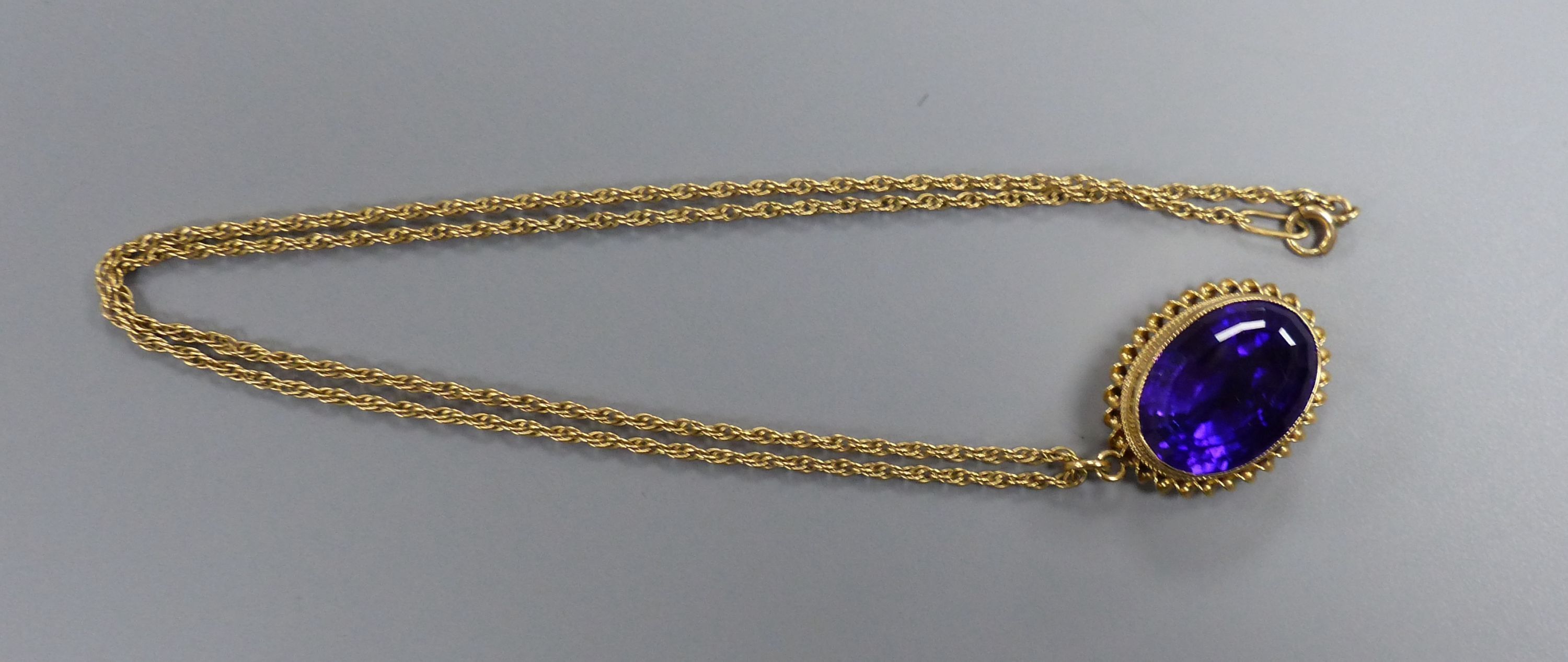 A modern 9ct gold and oval cut amethyst set pendant, 24mm, on a 9ct chain, 46cm,